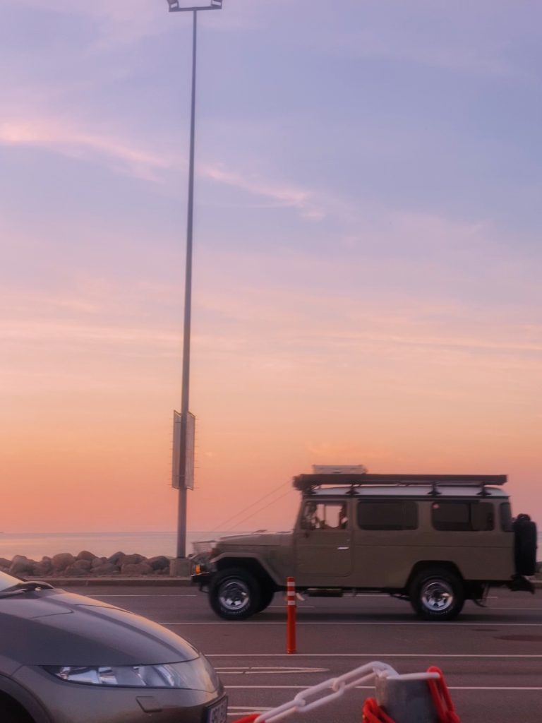 Land Rover Defender at golden hour sunset with expedition gear