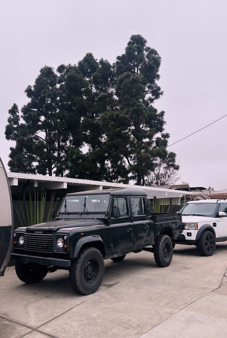 Classic blue Series III Land Rover parked by industrial building